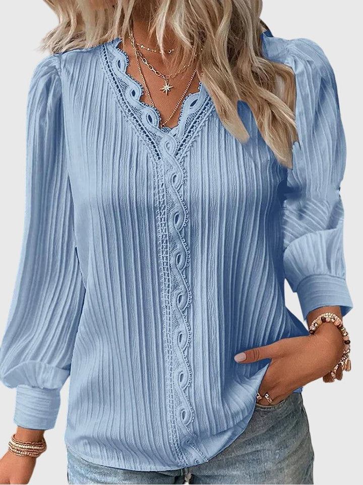 light blue pleated blouse with lace-trimmed V-neck and long sleeves