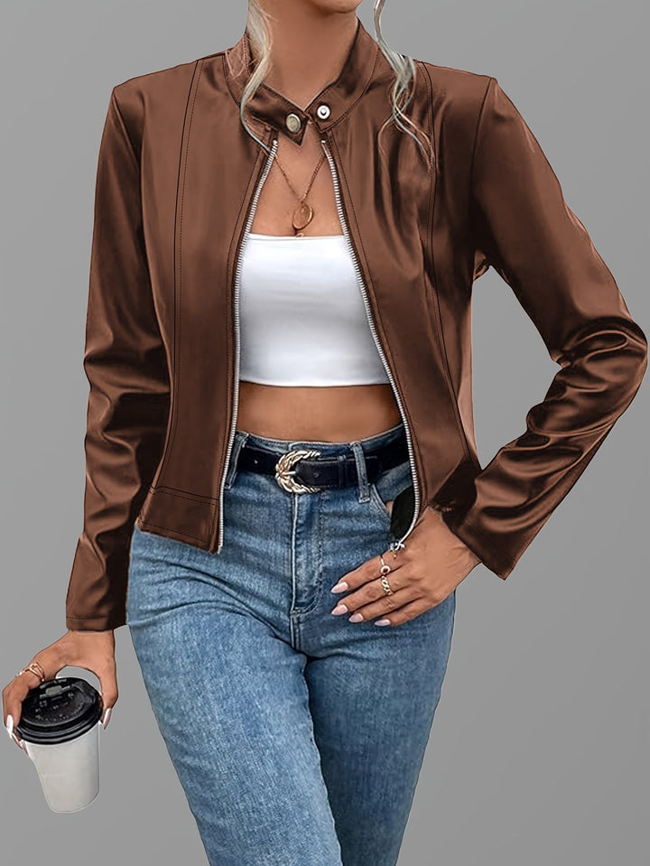 Brown zip-up leather jacket styled with white top and blue jeans