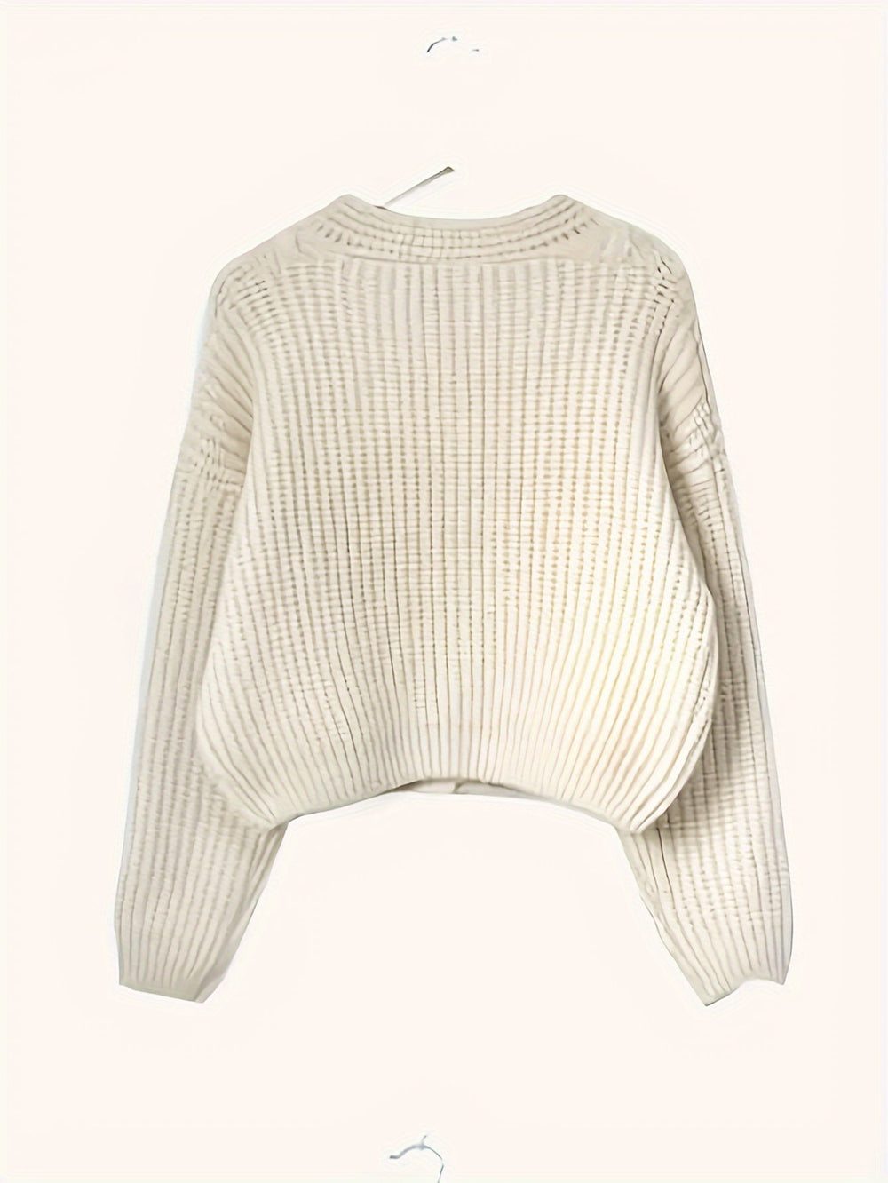 Ribbed cream jumper displayed on a hanger, showing textured knit back detail