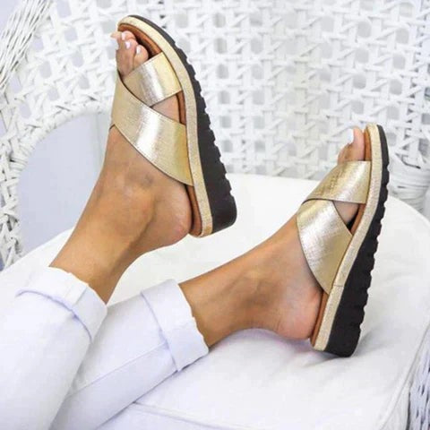 gold cross strap slide sandals styled with white cropped jeans
