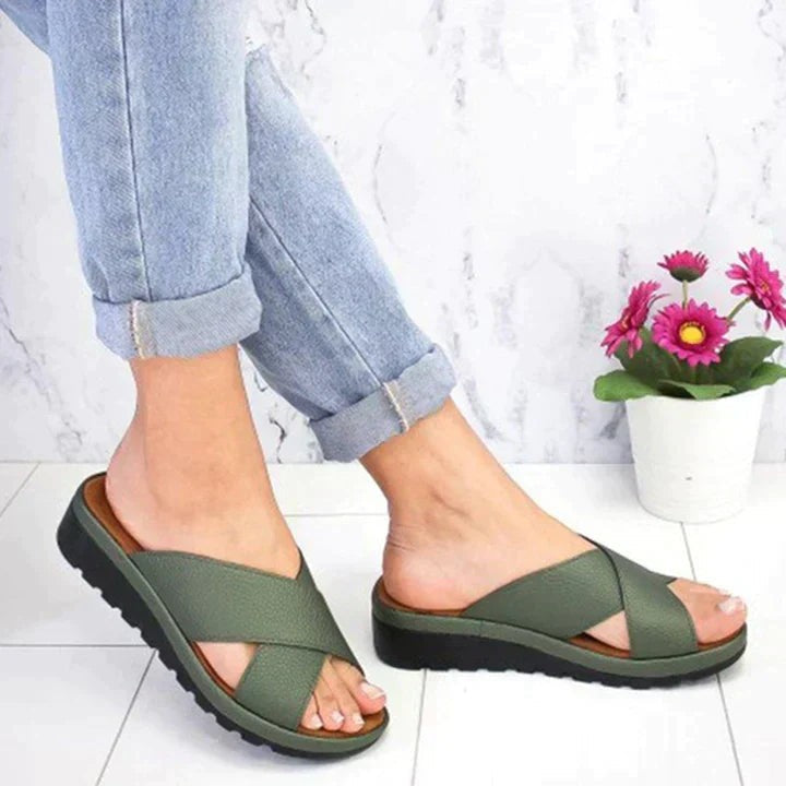 olive green cross strap slide sandals paired with rolled denim jeans