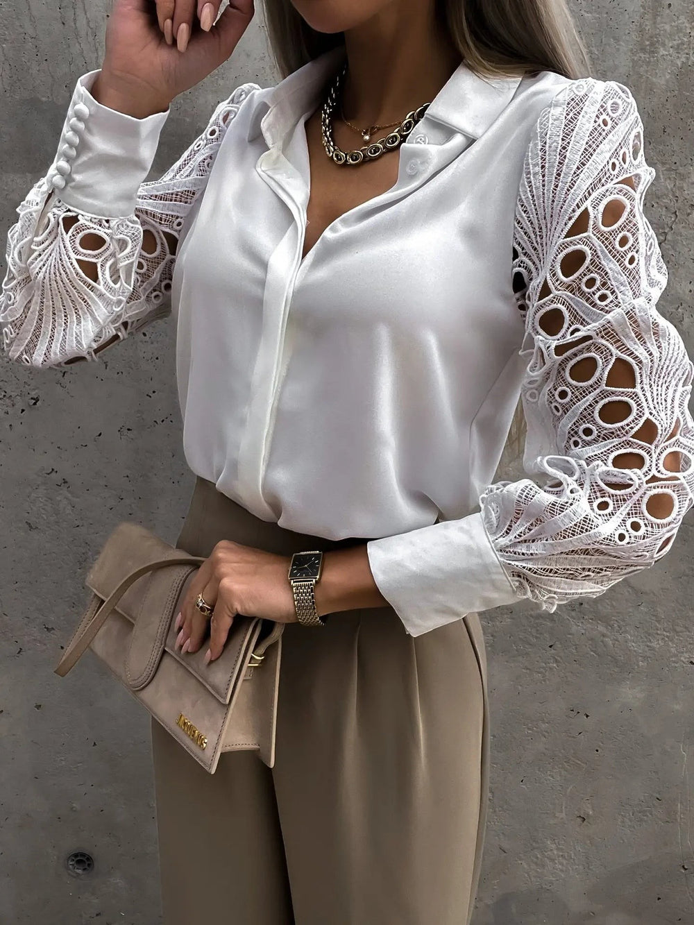 Ivory satin blouse featuring crochet lace sleeves paired with wide-leg trousers