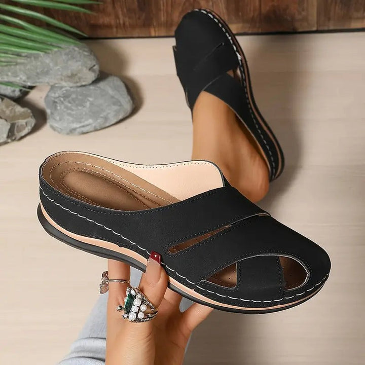 Black wedge sandals with crisscross straps and contrast stitching detail