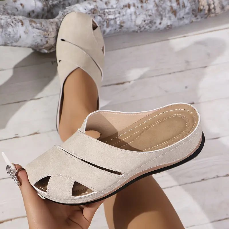 Beige suede wedge sandals showing peep-toe cutout and stitched straps