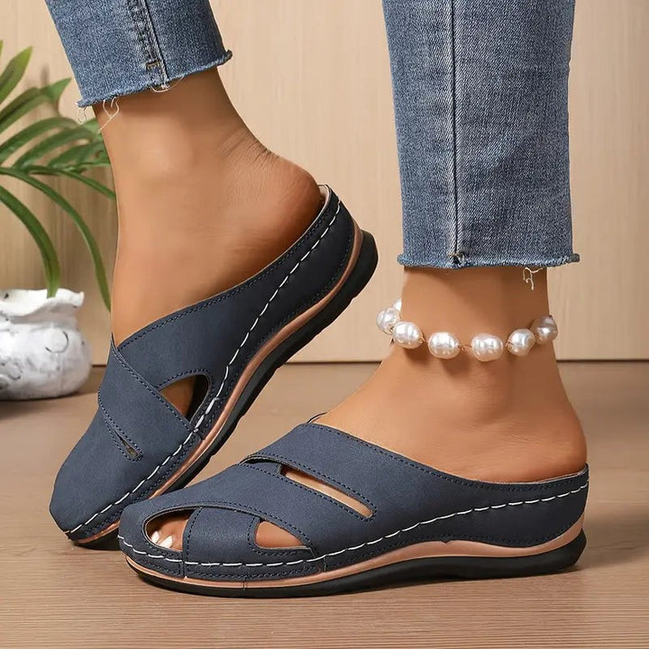Navy crisscross wedge sandals worn on foot with cropped denim jeans