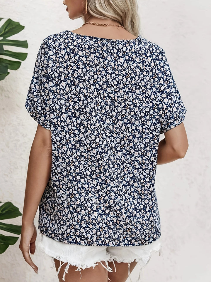Back view of navy ditsy floral blouse showing round neckline and relaxed short sleeves