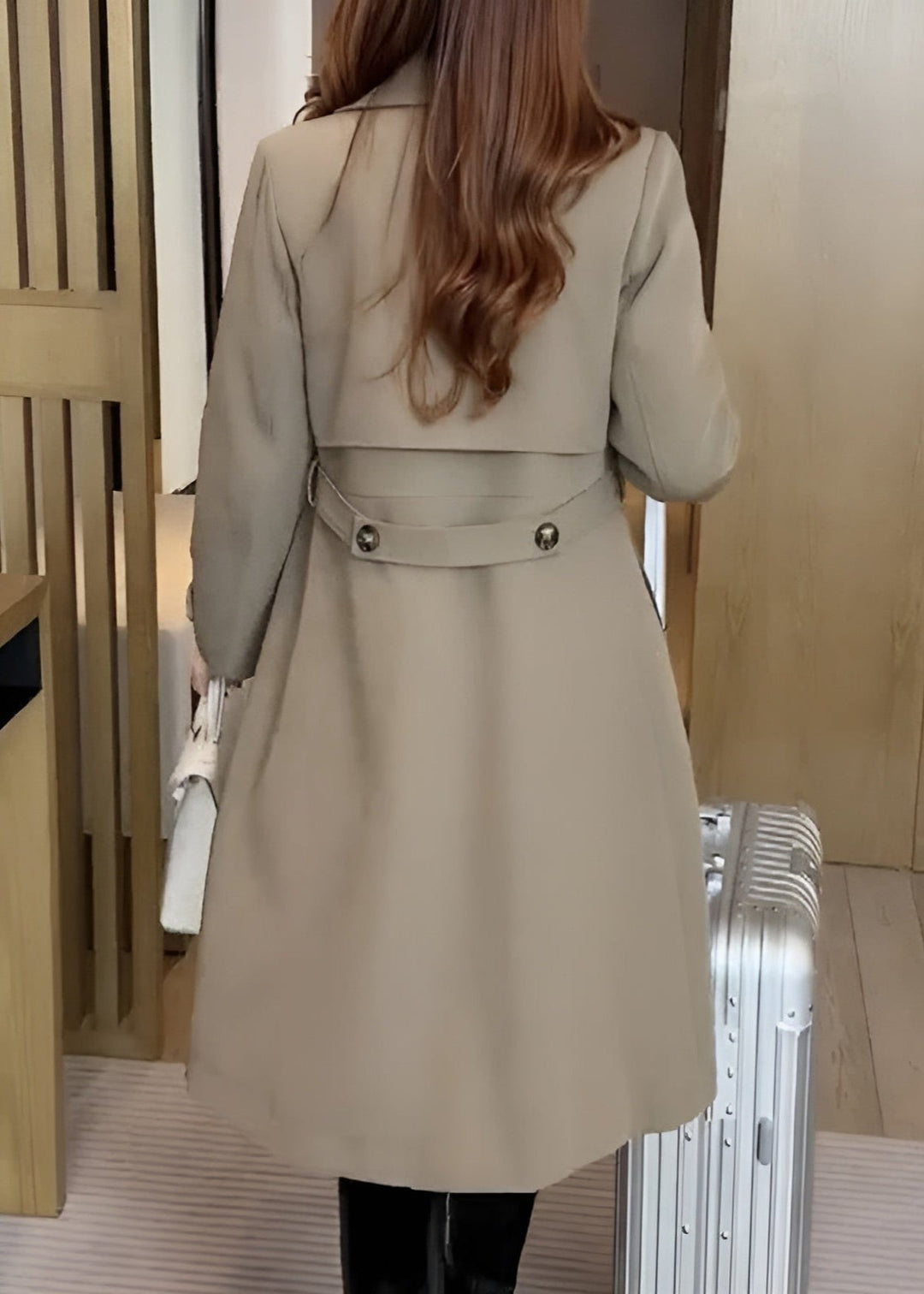 Back view of beige trench coat showing belted waist and button tabs
