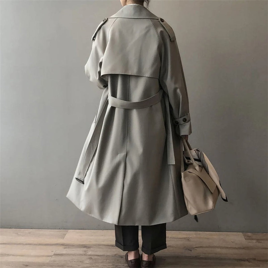 Rear view of belted grey trench coat showing oversized collar and long silhouette