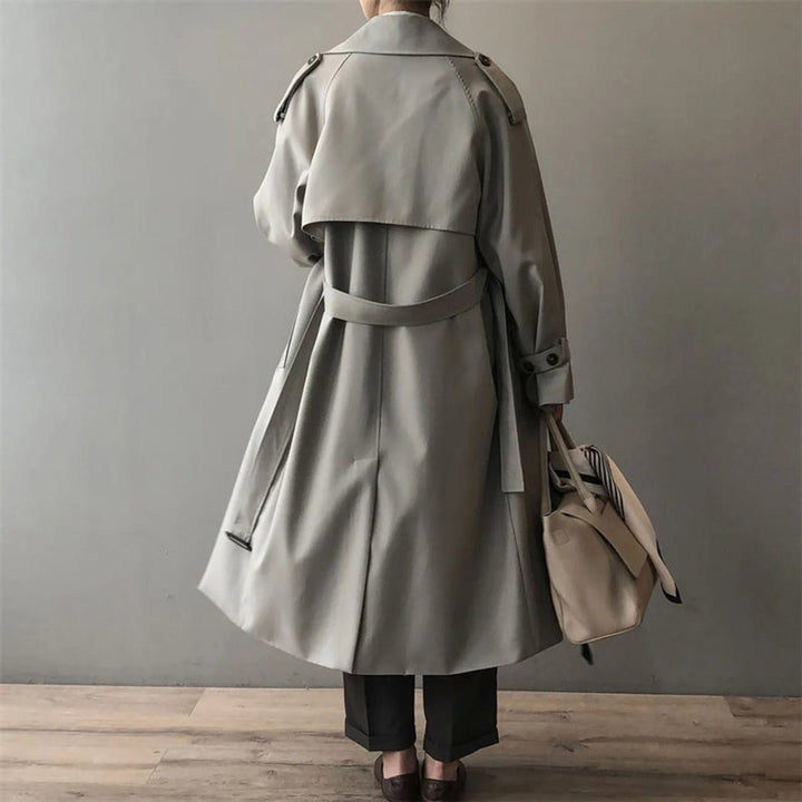 Rear view of belted grey trench coat showing oversized collar and long silhouette