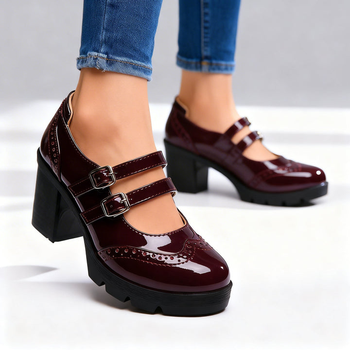 Burgundy patent double-strap Mary Jane pumps with wingtip brogue accents