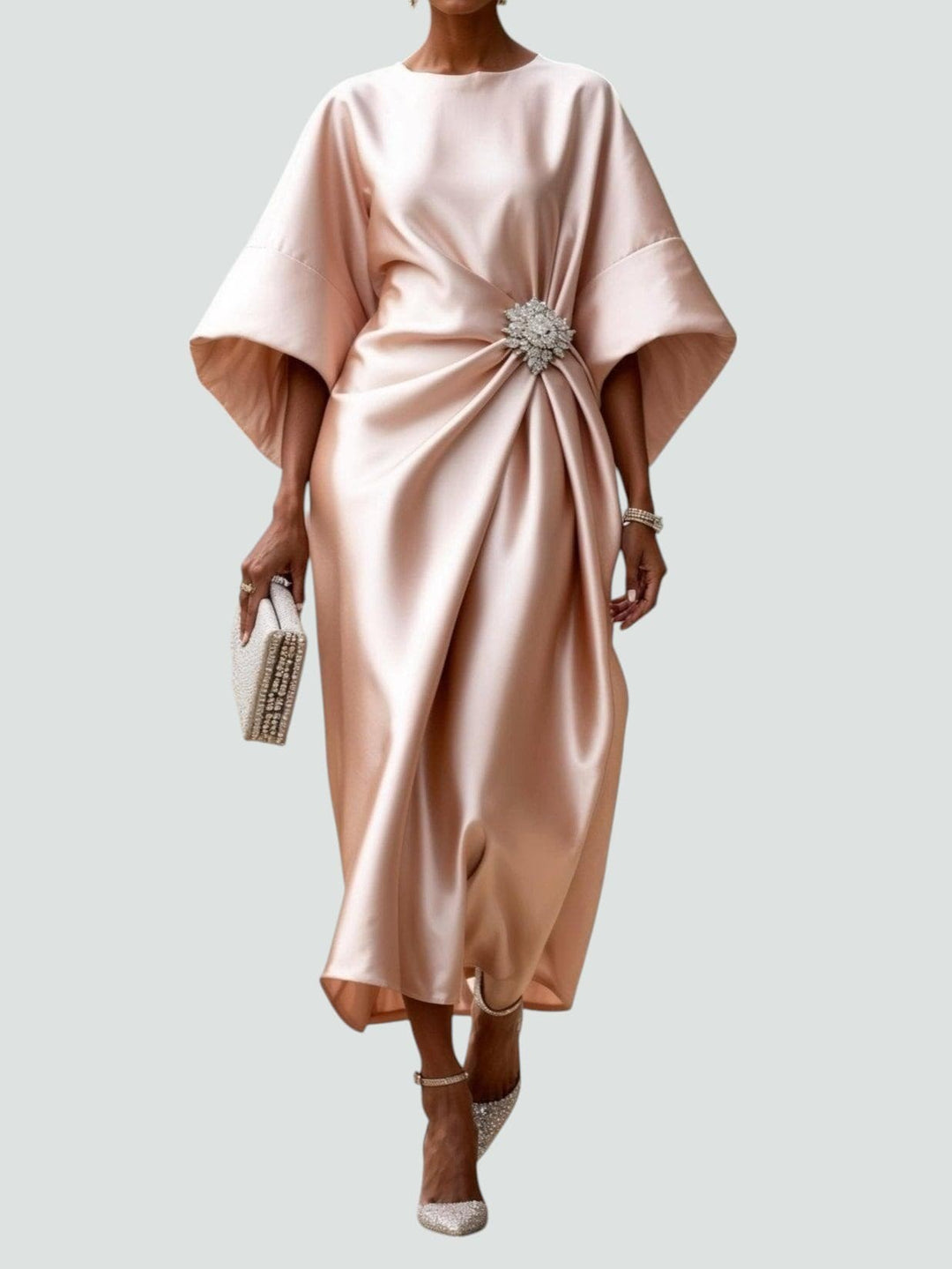 Blush pink satin midi dress with draped bodice and crystal brooch accent