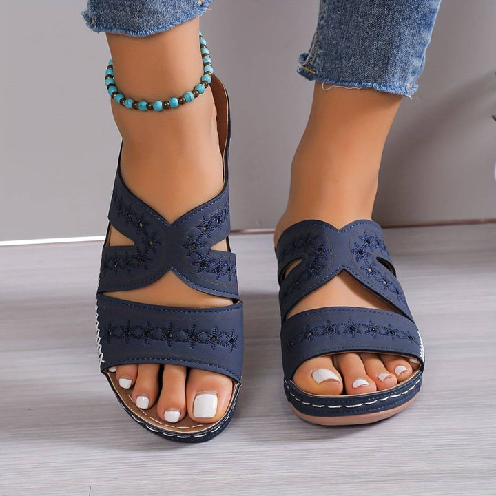 Navy wedge sandals with crossover straps and embroidered floral pattern