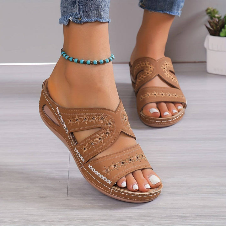 Tan embroidered wedge sandals with crossover straps and open-toe design