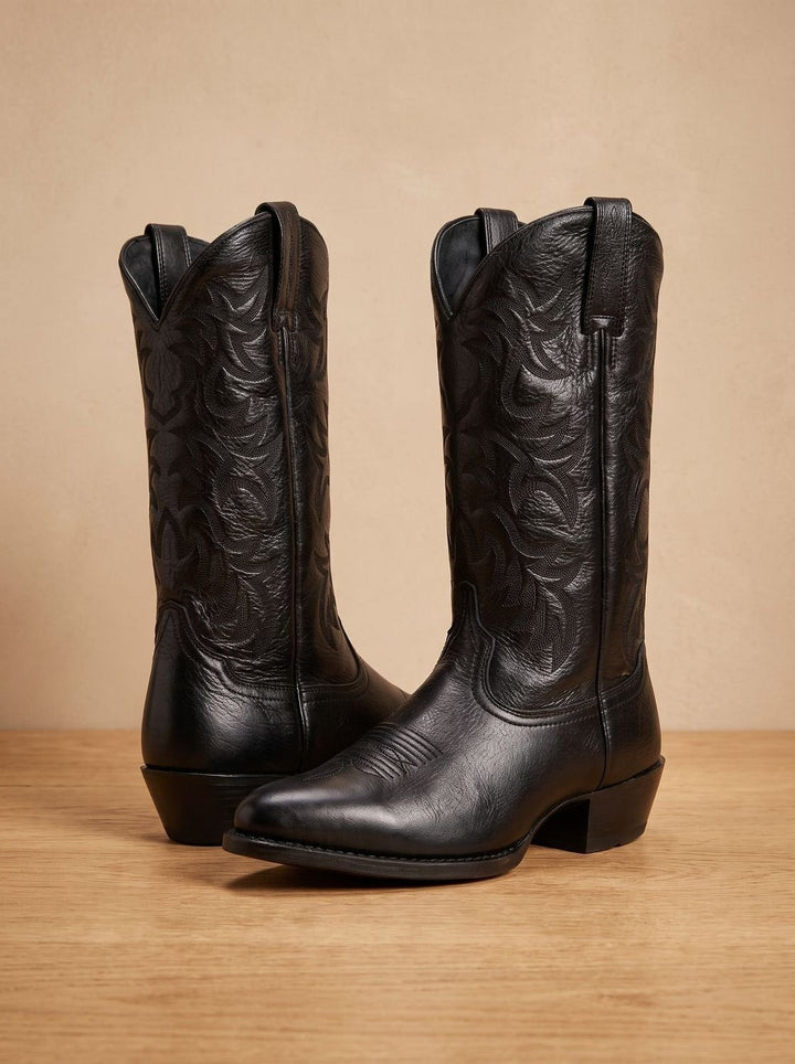 Pair of black leather cowboy boots with embroidered shaft and block heel, front view