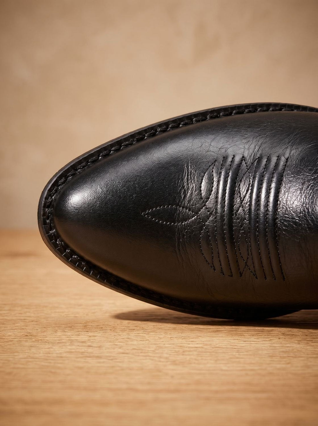 Close-up of black leather cowboy boot toe showing stitched design and block heel