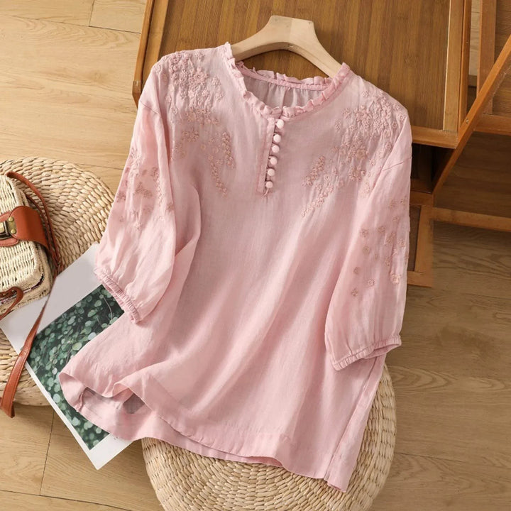 pink floral embroidered blouse with ruffled V-neck and button placket