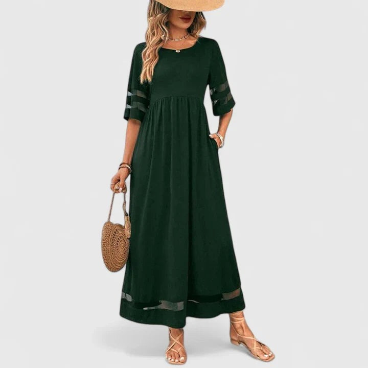 Dark green maxi dress with mesh sleeve stripes and straw bag