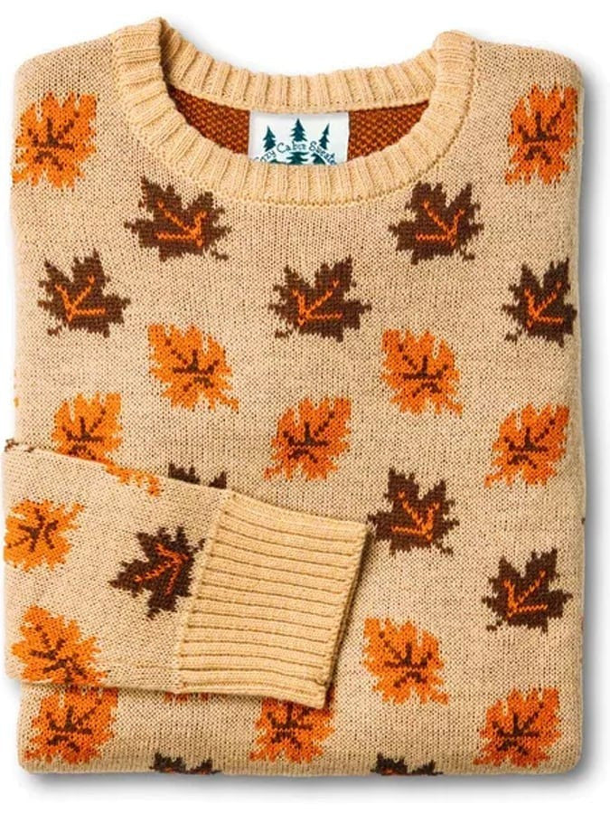 Tan crew neck sweater with scattered orange and brown maple leaf pattern