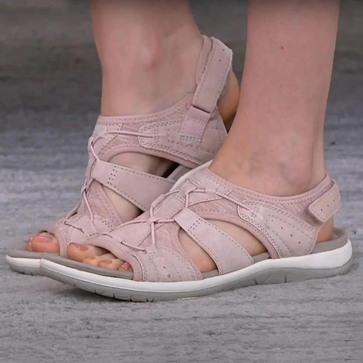 Blush pink suede fisherman sandals with woven lace-up front worn on feet