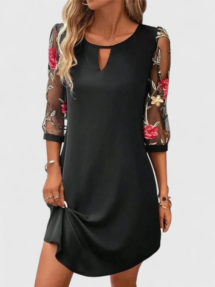 Black shift dress featuring mesh floral embroidered sleeves and keyhole neckline
