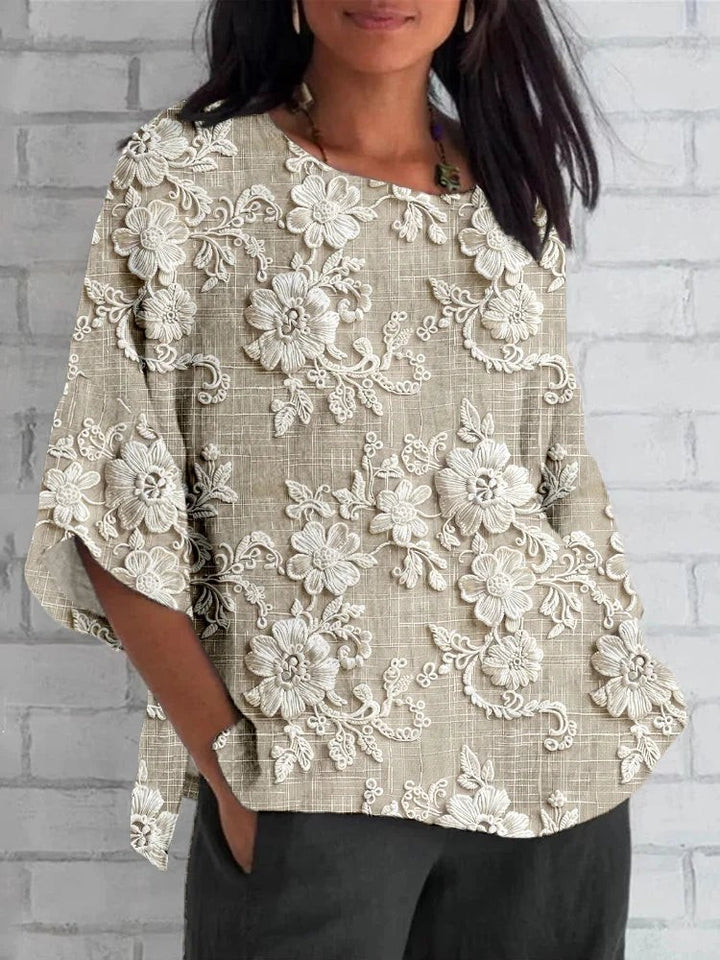 Beige floral embroidered blouse with three-quarter sleeves and round neckline