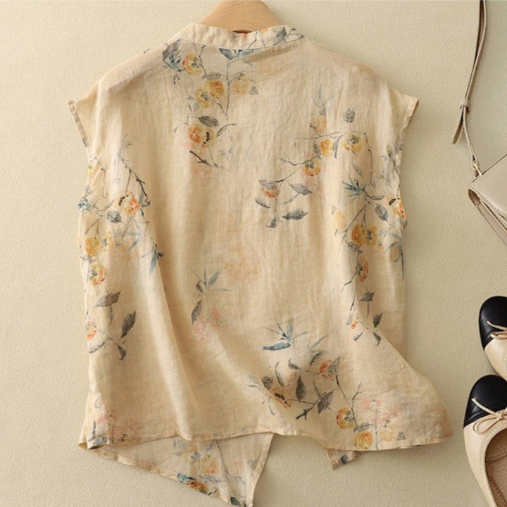 Back view of beige floral linen top with cap sleeves and split hem
