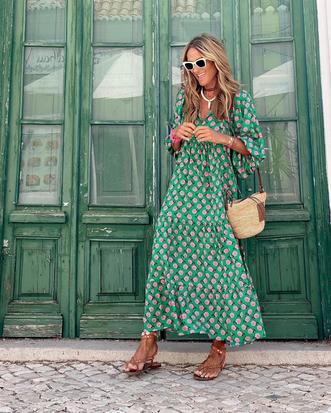 Green tiered maxi dress with pink floral print paired with studded sandals