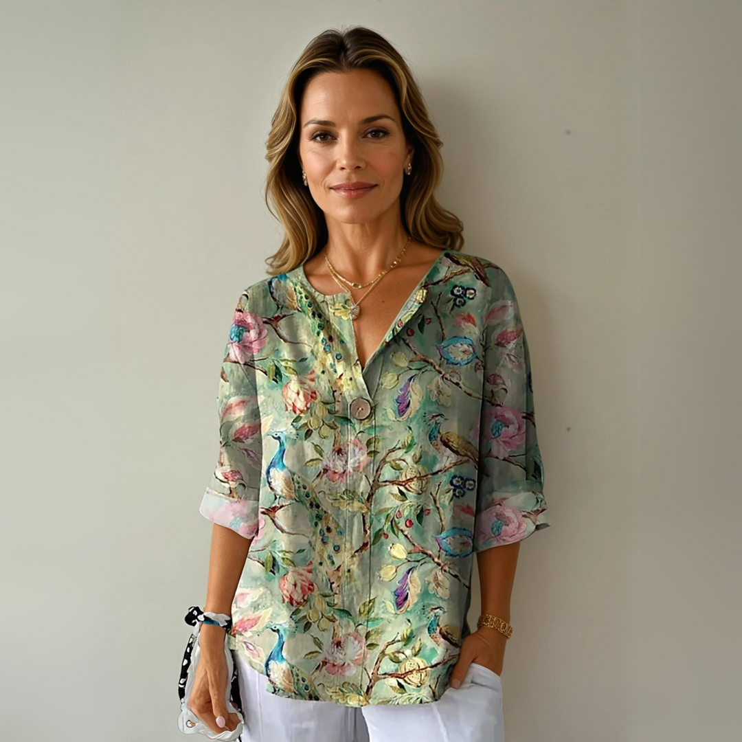 Green floral blouse with peacock print and rolled cuffs on three-quarter sleeves