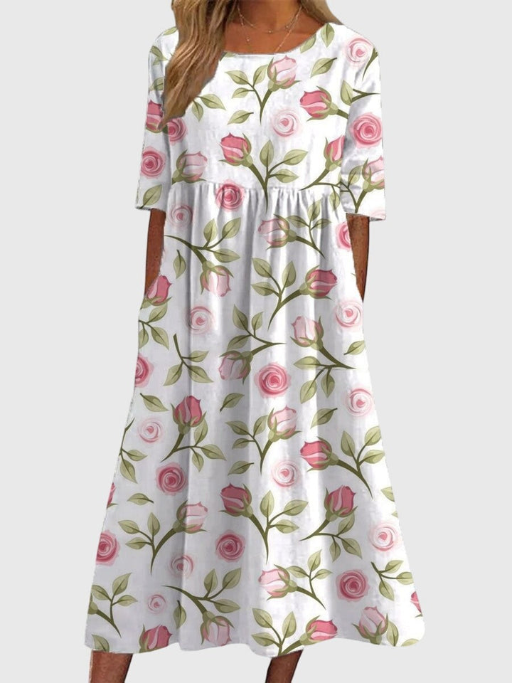 white midi dress featuring pink rose print and empire waist