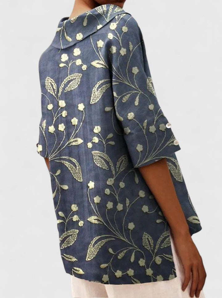 Back view of navy blue floral tunic showing hood and button sleeves