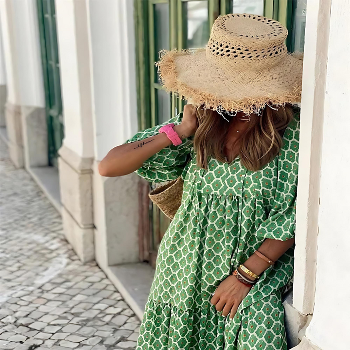 Green geometric print tiered dress paired with straw hat and woven bag