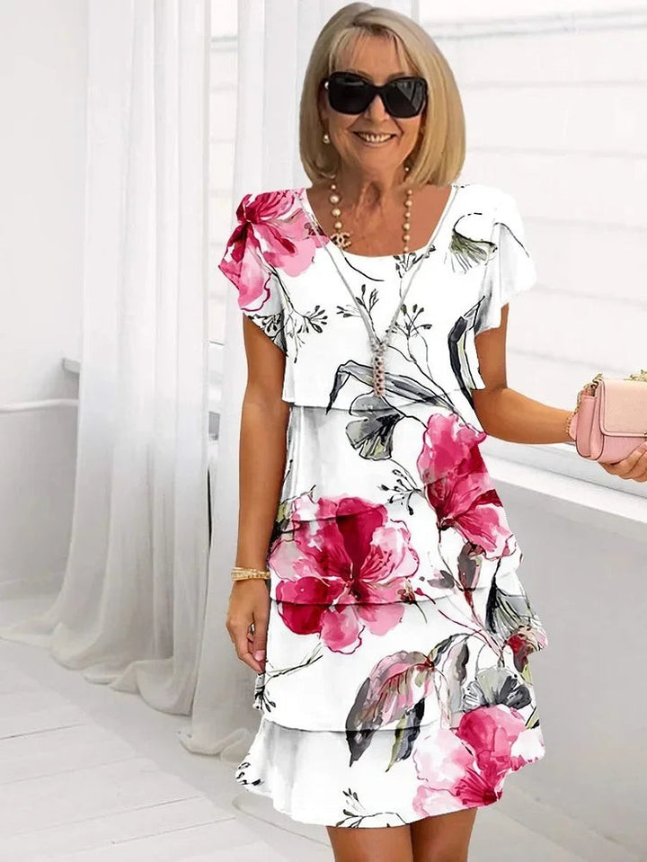 White floral tiered dress with ruffle sleeves and pink flower print