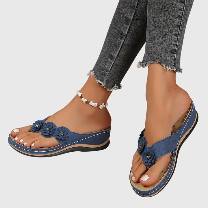 Navy floral wedge flip-flops displayed side by side on model