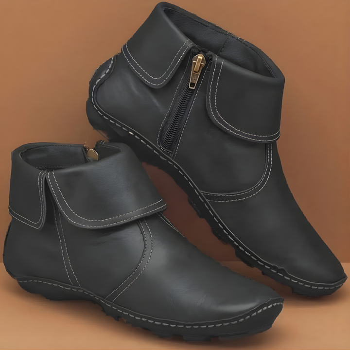 Black leather ankle boots showing fold-over collar and gold-tone side zip