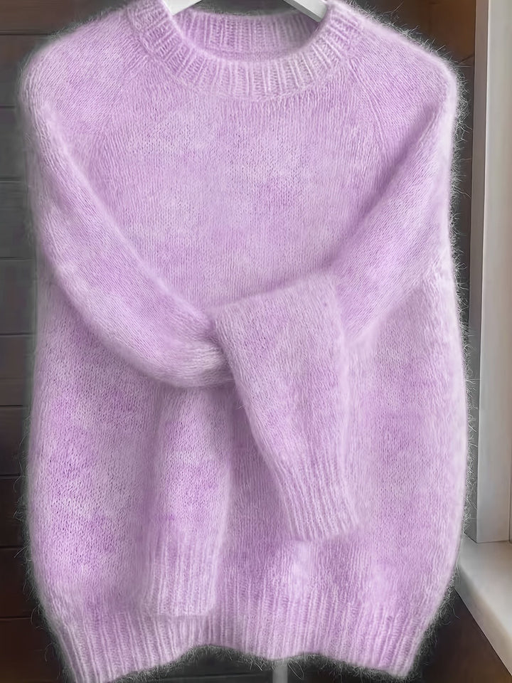 Lilac fuzzy knit jumper with ribbed hem draped on a hanger