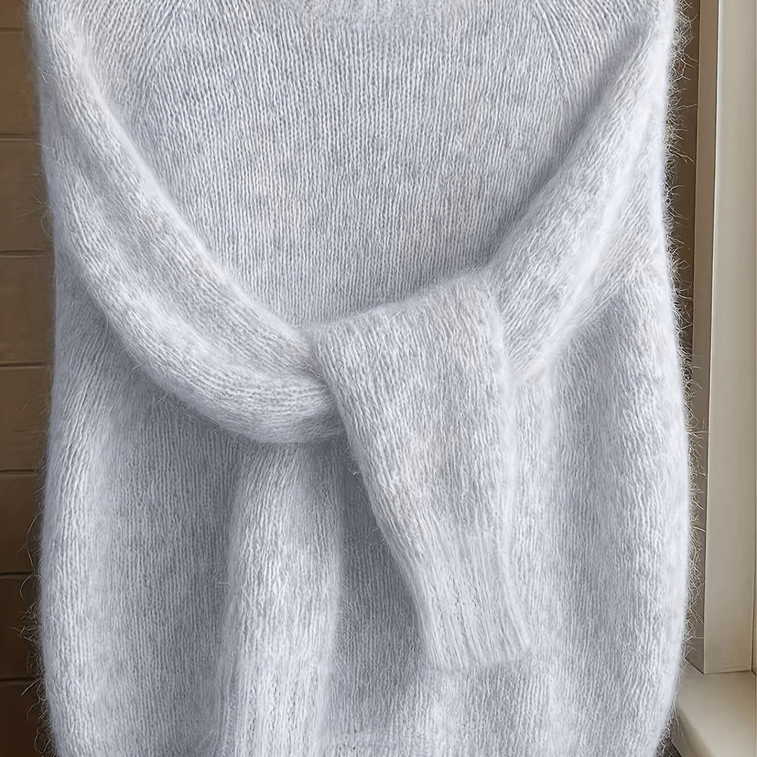 Close-up of pale grey fluffy knit jumper with ribbed sleeve cuffs