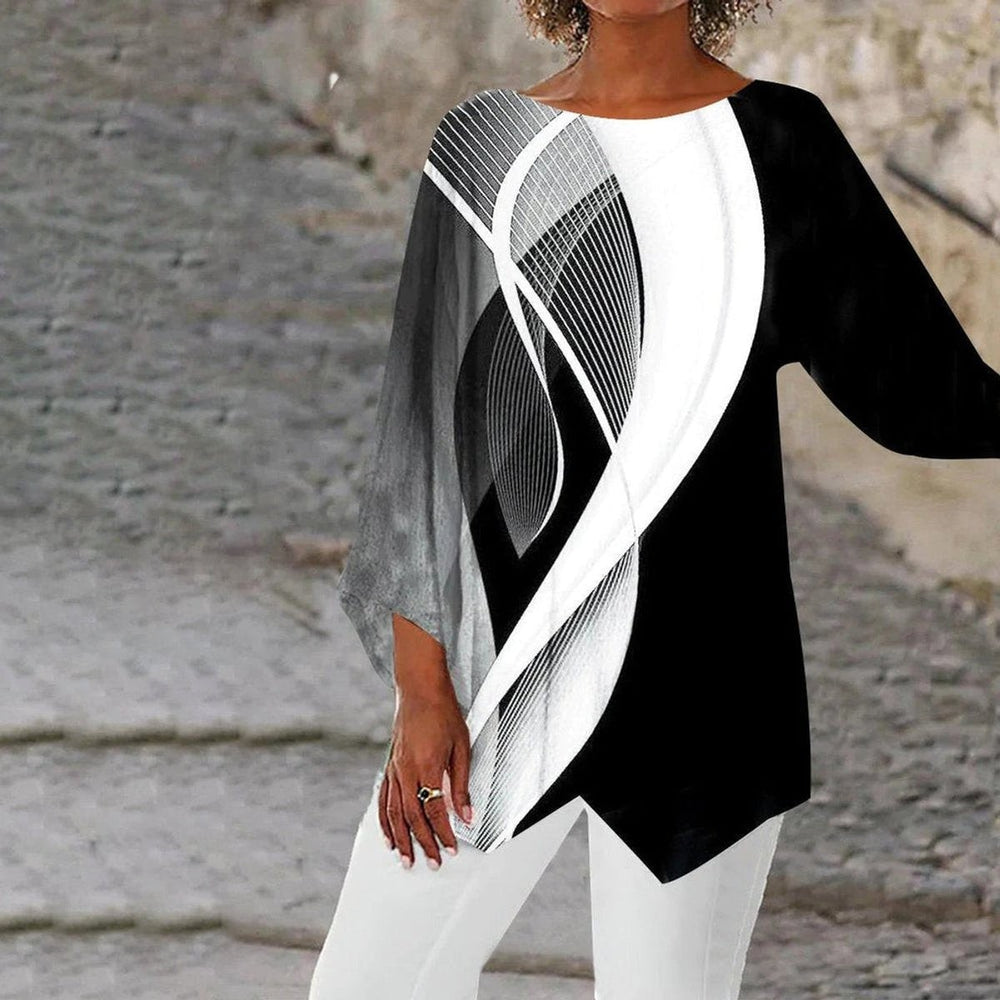 Abstract swirl-print asymmetric tunic top paired with white pants, close-up view