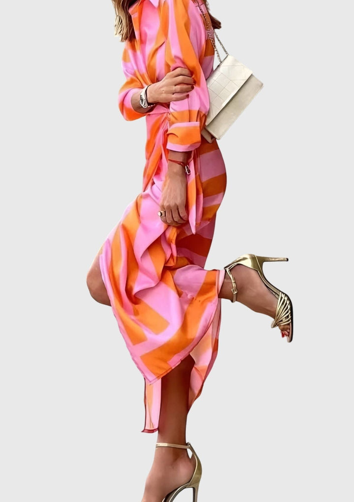 Side view of pink and orange wrap dress with flowing skirt and gold sandals