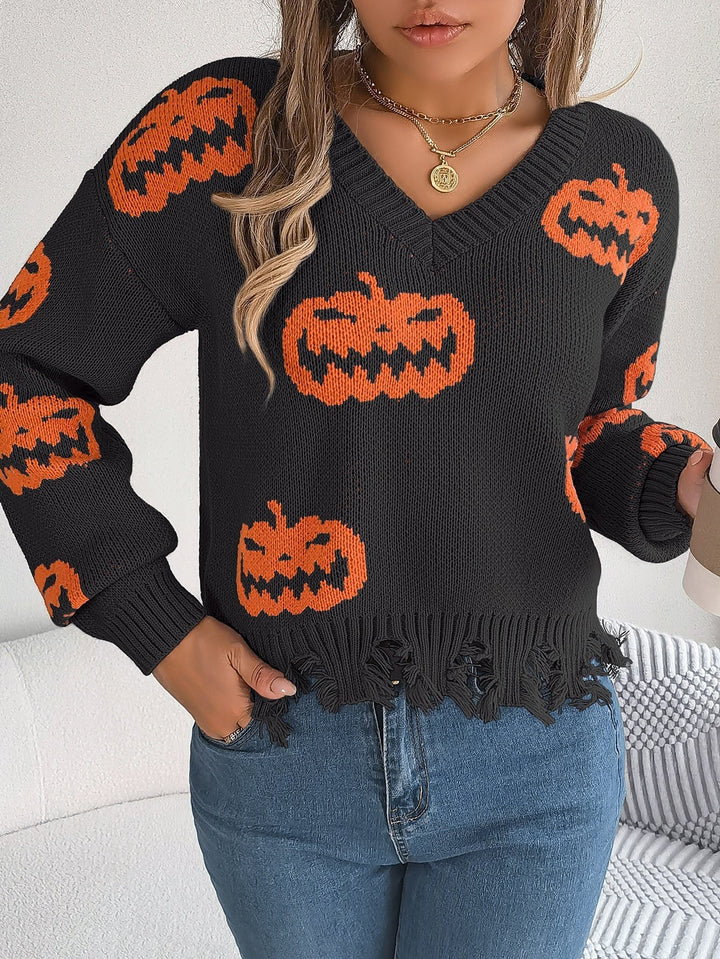 Model wearing black pumpkin print sweater with distressed fringe hem