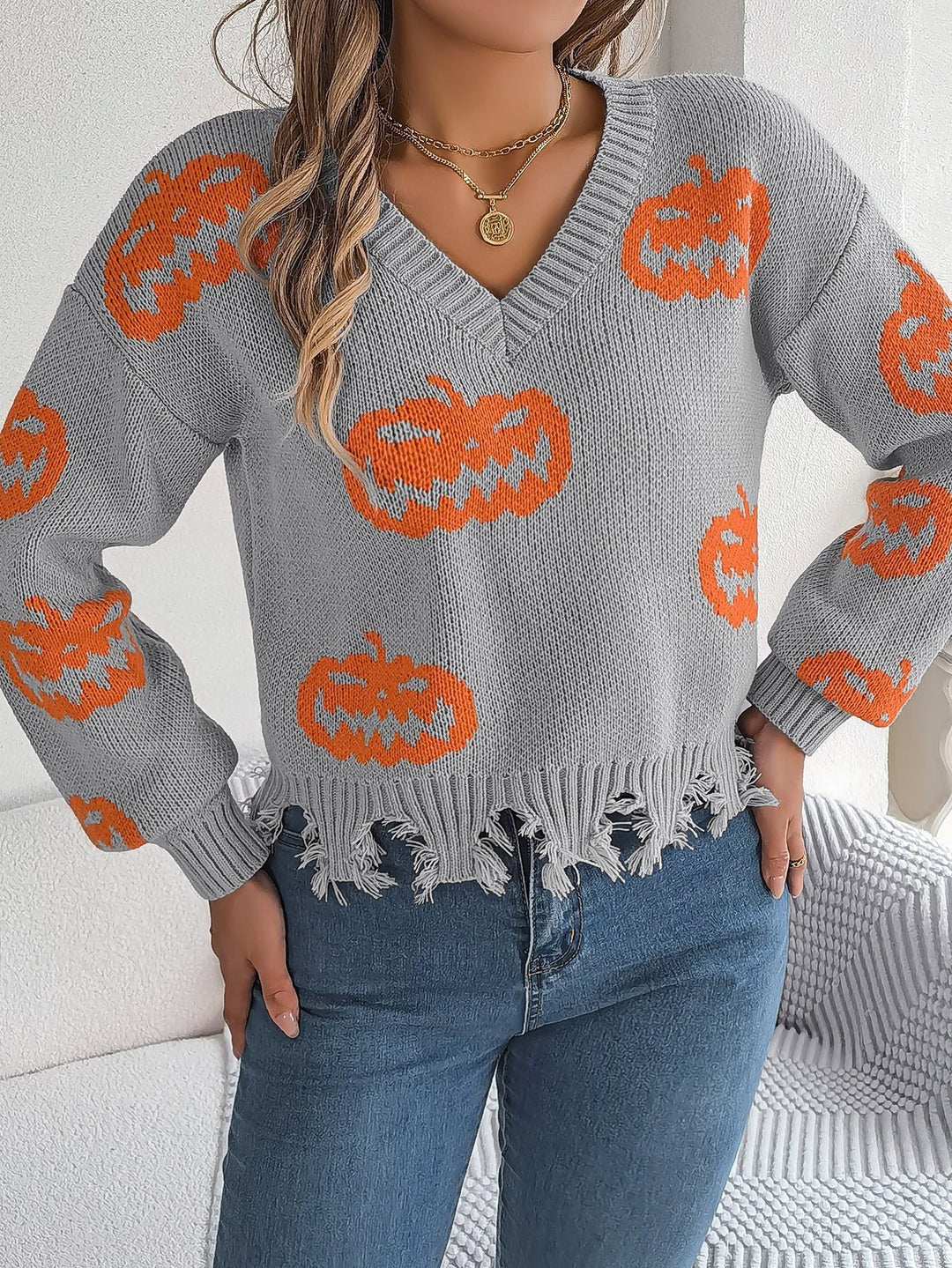 Gray Halloween sweater with orange pumpkin faces and fringed bottom hem