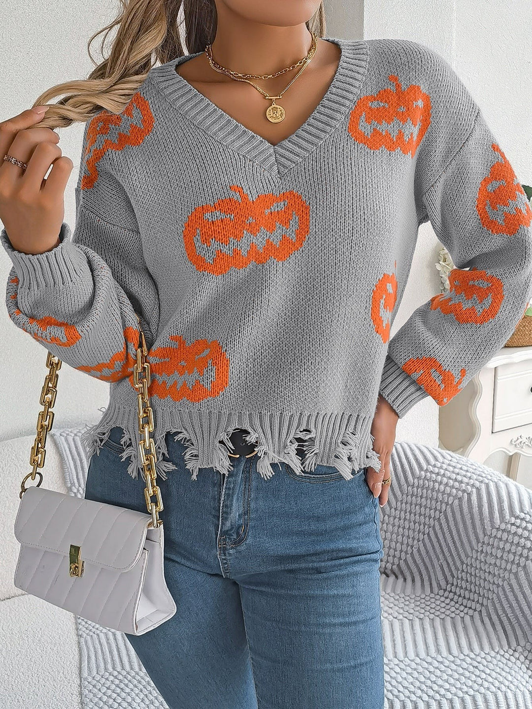 Back view of gray pumpkin print sweater with distressed knit hemline
