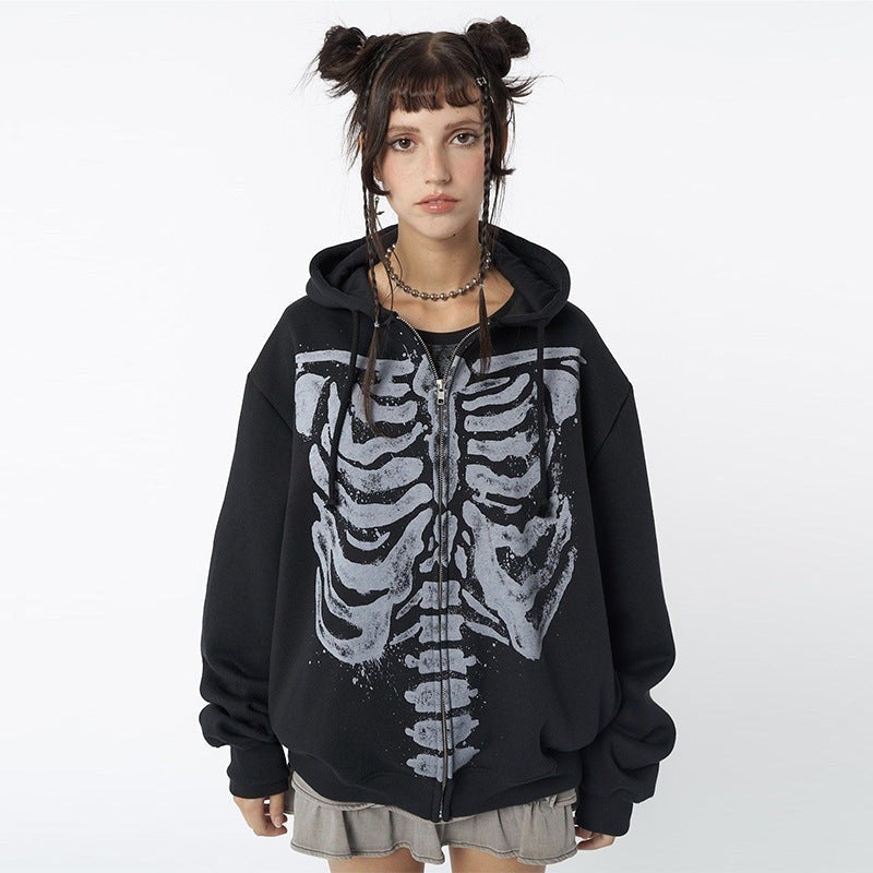 Front view of oversized skeleton print hoodie paired with a pleated mini skirt