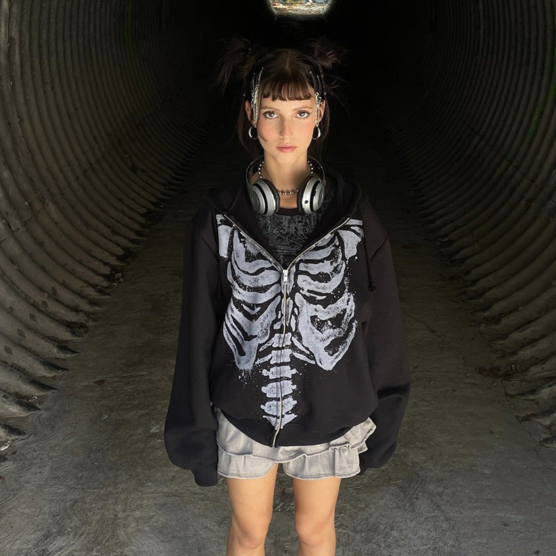 Skeleton rib cage print zip-up hoodie worn with headphones in a tunnel setting