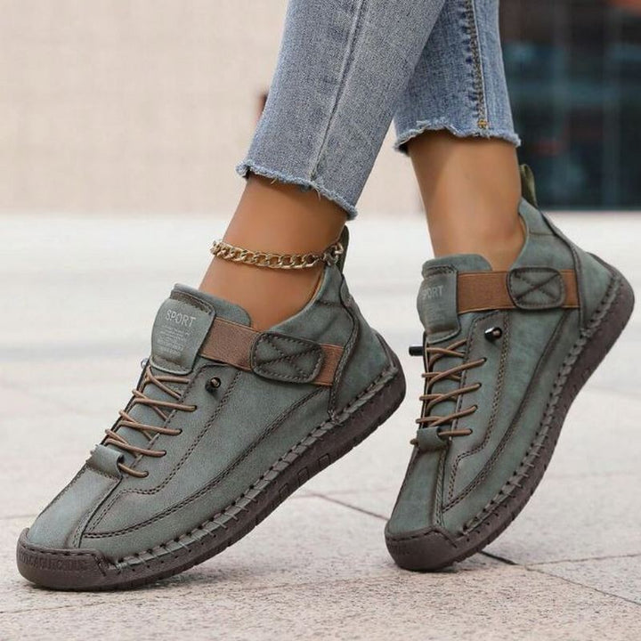 Olive green leather sneakers with strap closure and textured outsole