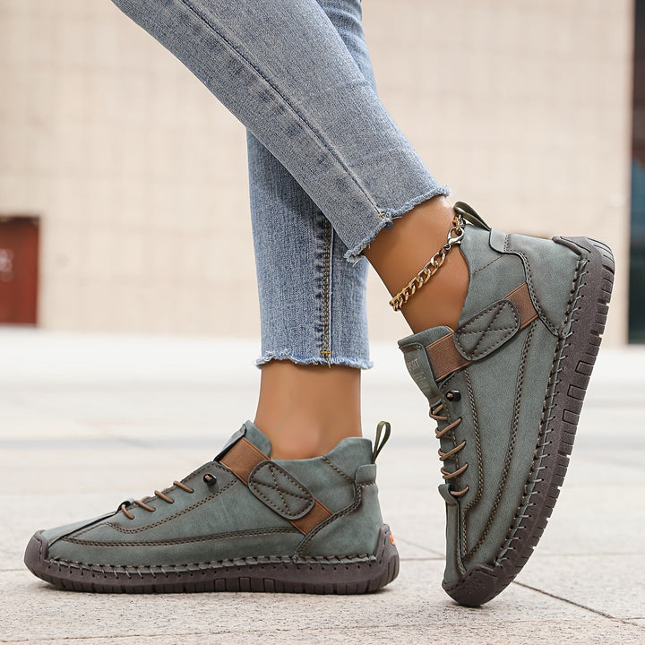 sage green leather sneakers with hand-stitched detail and lace-up front