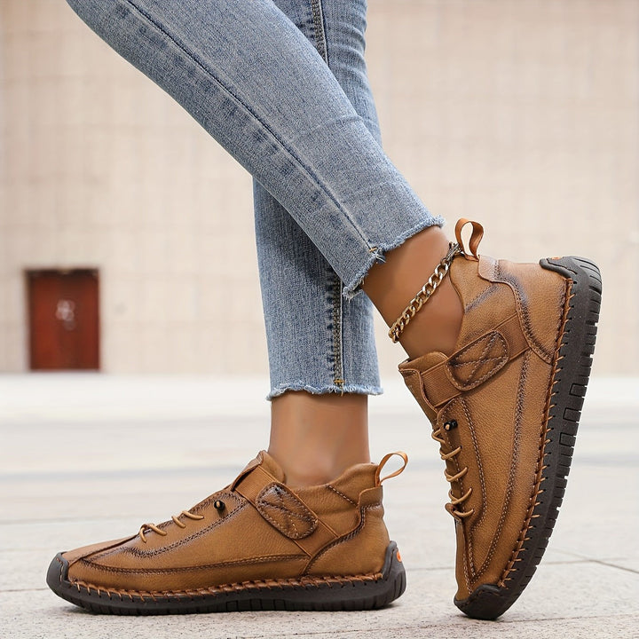 brown leather sneakers showing hand-stitched panels and lace-up design