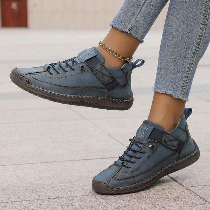 denim blue leather sneakers featuring stitched panels and pull tab heel