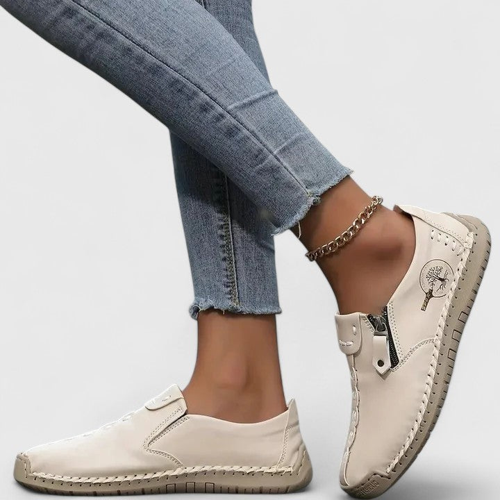 Cream leather slip-on sneakers with side zipper and whipstitch trim detail
