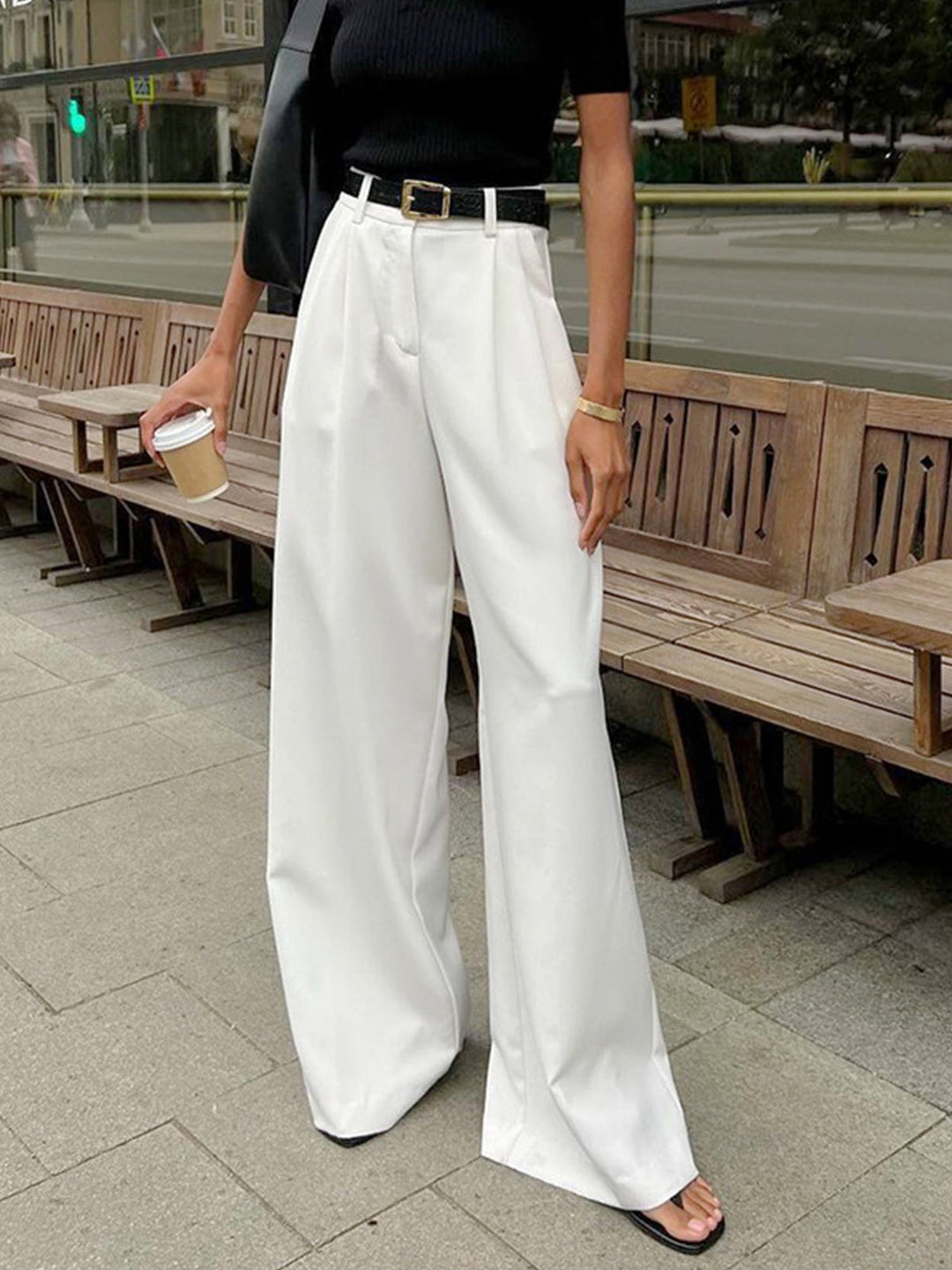 White high-waisted wide-leg trousers styled with black belt and top