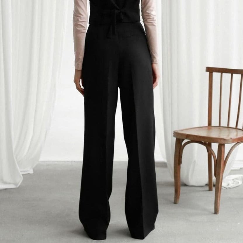 Black wide-leg pants shown from behind with wide hem